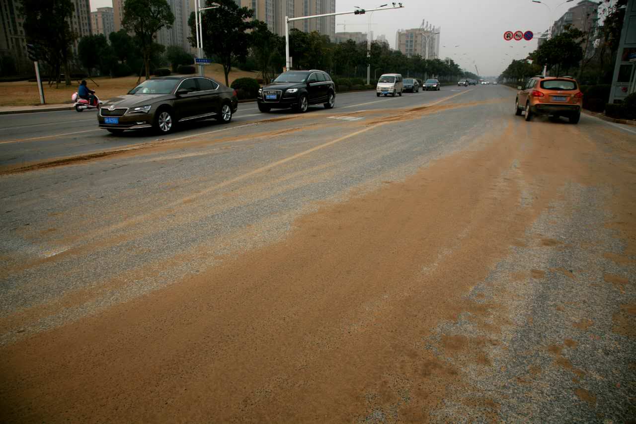 疑车辆抛洒数百米路面变土路